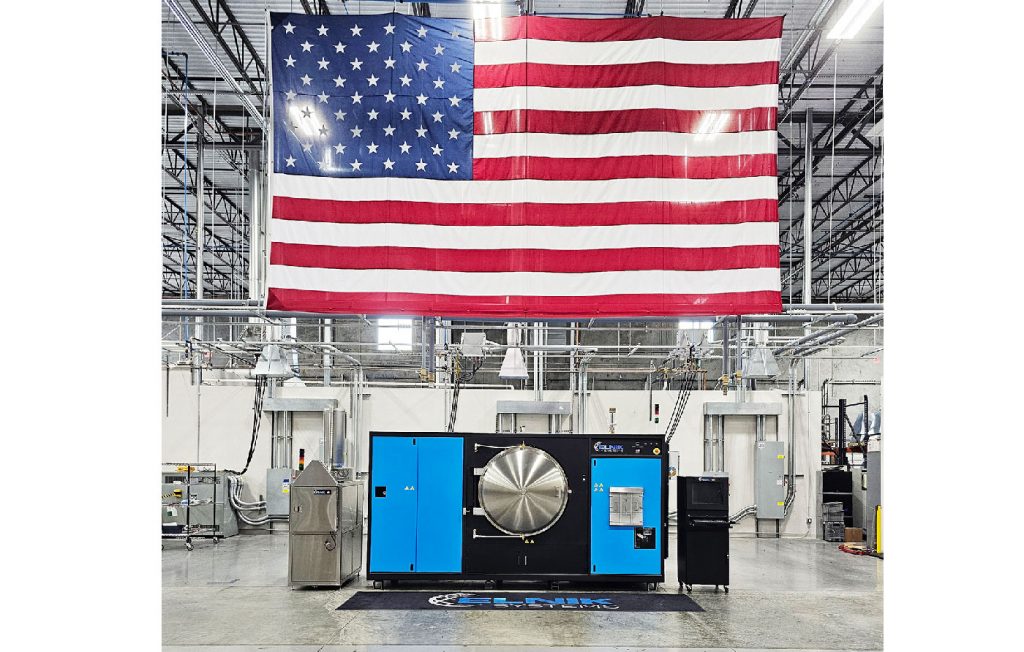 Fig. 2 A MIM 3045 furnace and CD3045 oven under a large USA flag. The flag’s height (15 ft./4.5 m) is same as the height of the old Elnik building in New Jersey (Courtesy Elnik Systems)