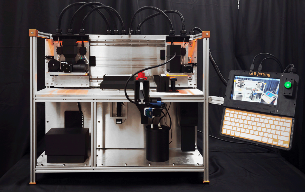 Fig. 6 The Educator is designed as a Binder Jetting starting point, yet offers best-in-class technical and application support. It features a 125 mm wide build box, ideal for producing stress test dog bones or sampling new materials. The Educator, along with its highly customisable counterpart, The Researcher, can both be operated within inert environments, enabling the safe use of reactive powders such as aluminium and titanium. A range of accessories is also available, including customised hoppers, recoaters, and a drop watcher (Courtesy B-jetting LLC)