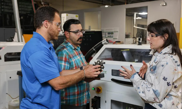 (L-R) Corson Cramer, Trevor Aguirre and Amy Elliott discuss the additively manufactured silicon carbide gyroid component (Courtesy ORNL, US DoE) 