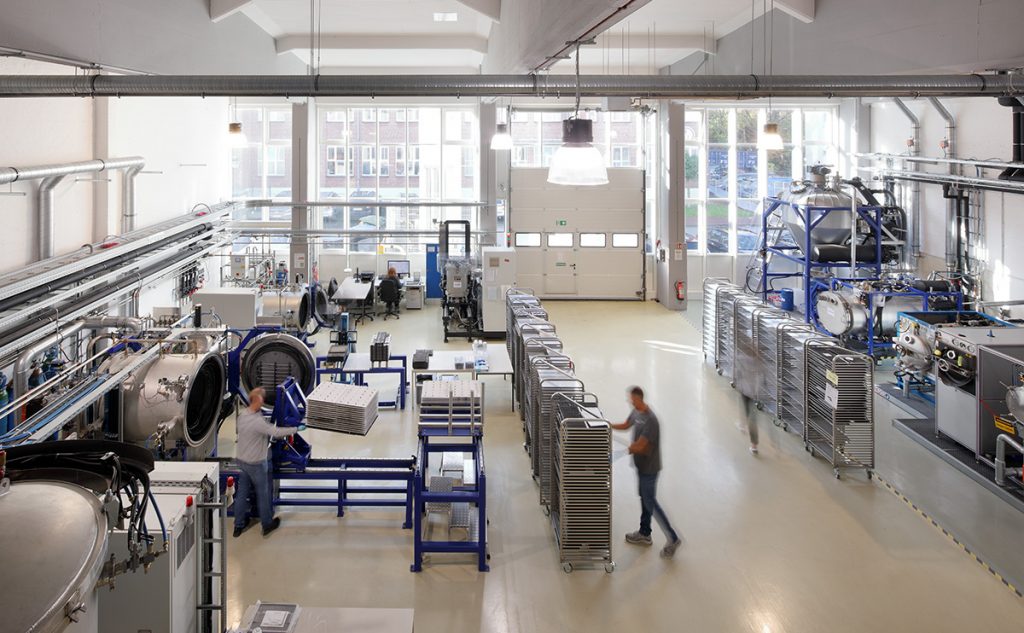 Fig. 3 Element 22’s production hall. On the left are the sintering furnaces, and on the right are the debinding units and the distillation plant (Courtesy Element 22)
