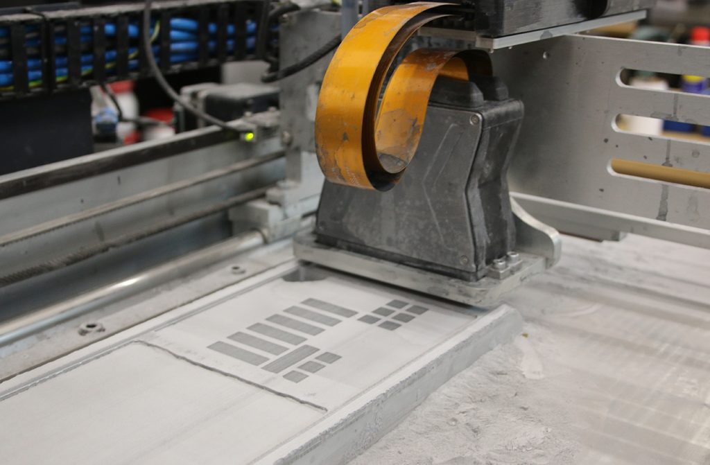 Fig. 1 Binder Jetting in operation, with the printhead depositing binder onto the powder bed. The process is gaining traction for high-throughput and multi-material applications (Courtesy Atomik AM)