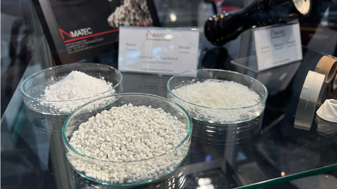 Fig. 2 CIM feedstocks, binders and sample parts on display at Inmatec's stand at Ceramitec 2022