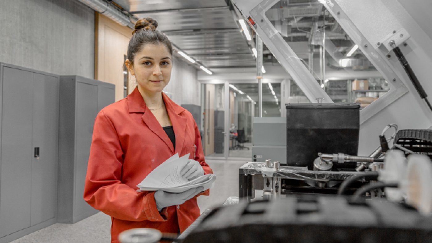 Fig. 5 Alice Rosa, MA student at SUPSI, with the laboratory's Innovent+ Binder Jetting machine from ExOne (Courtesy SUPSI)