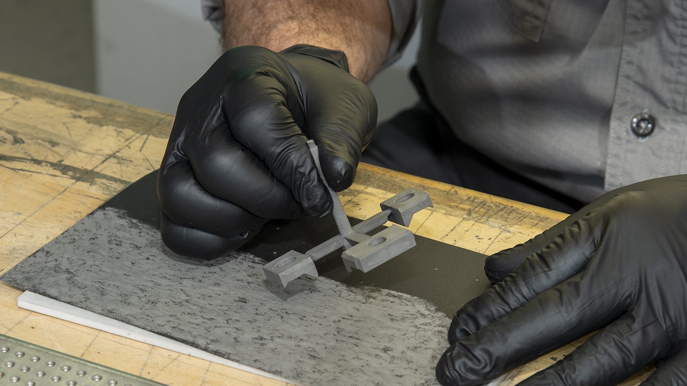 Fig. 5 Parts are removed from the sprues (which are recycled into feedstock) and then placed on perforated stainless steel trays in readiness for solvent debinding (Courtesy TriTech Titanium Parts)