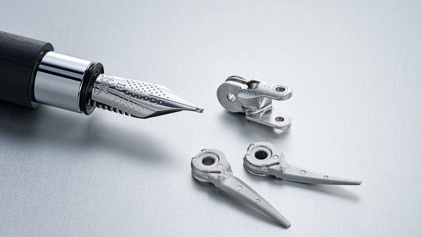 Fig. 10 The tip core (upper part) is an articulated piece of an instrument control system for robot-assisted surgery, made from 17-4 PH stainless steel. The lower parts form a pair of scissors that are used as a cutting instrument in robot-assisted surgery and are made of AISI 420 martensitic stainless steel (© 2023 Distalmotion. Image used with permission)